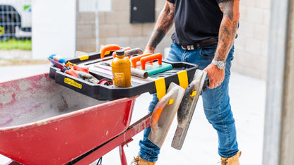 Barrow Boss wheelbarrow workstation attachment carrying tools and equipment on a construction site.
